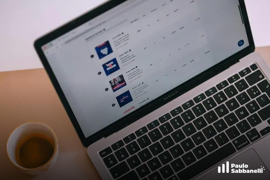 Notebook ao lado de xícara de café exibindo lista de publicações agendadas em rede social