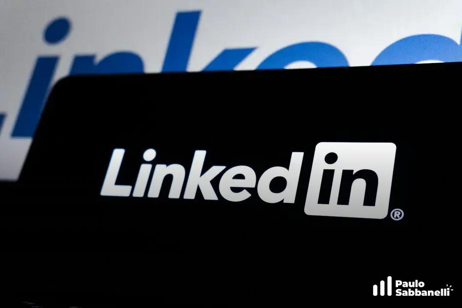 Ícone do LinkedIn iluminado na tela de um celular, remetendo a conexões profissionais online