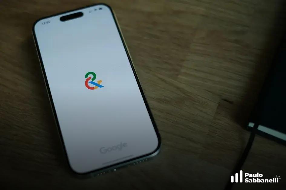 Celular sobre mesa de madeira exibe o logotipo colorido do Google Ads carregando
