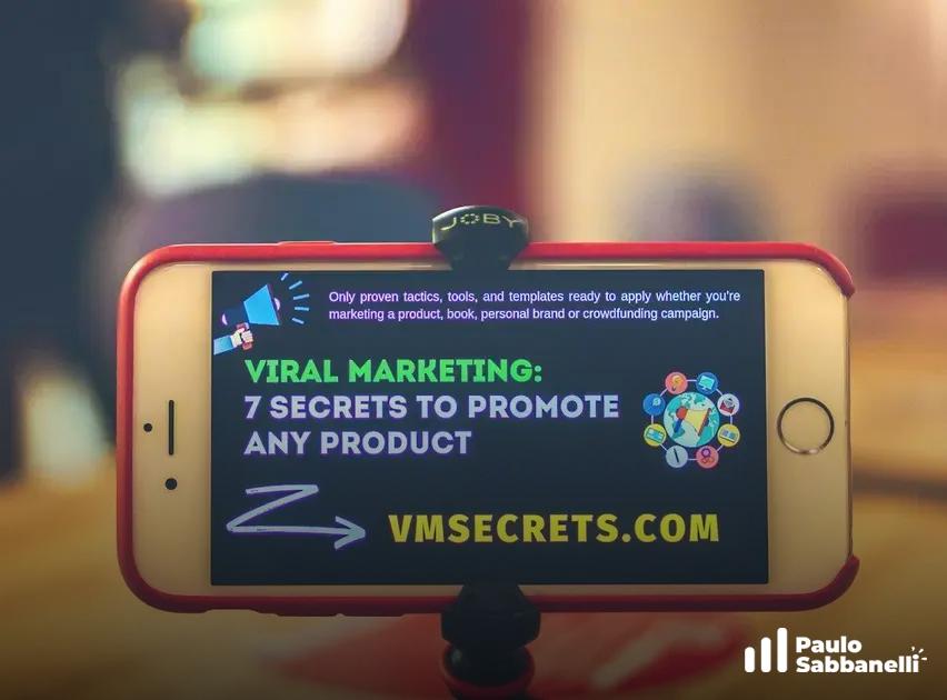 Celular preso a um tripé exibindo um slide promocional sobre marketing viral