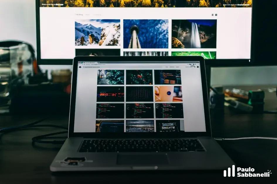 Notebook exibe galeria de fotos de paisagens com monitor externo mostrando as mesmas imagens ao fundo
