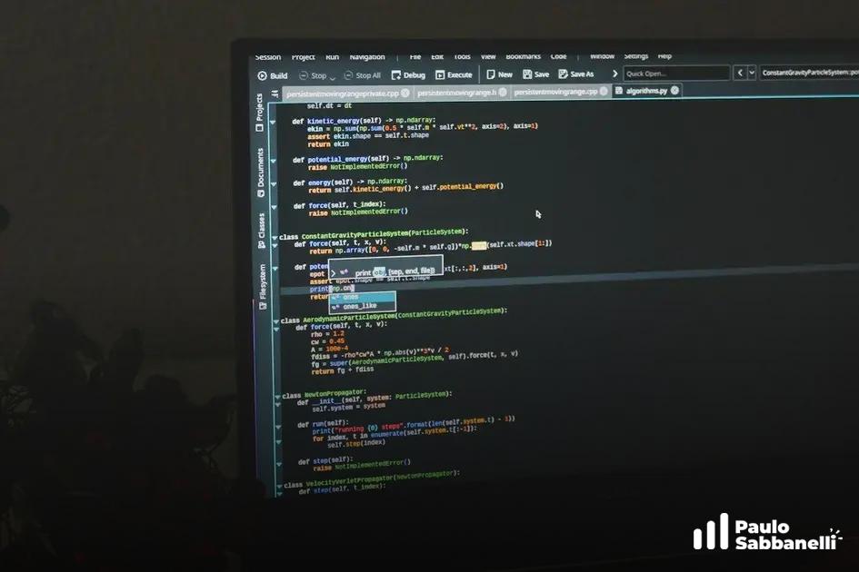 Monitor visto à distância em cômodo escuro, exibindo código Python na aba algorithm.py