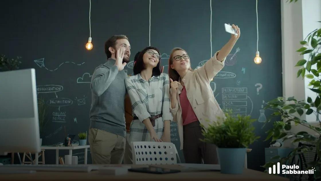 Três colegas de trabalho sorrindo e tirando uma selfie em um escritório com lousa ao fundo