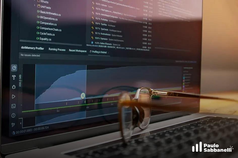 Óculos apoiados sobre um notebook com o dotMemory Profiler exibindo um gráfico de uso de memória