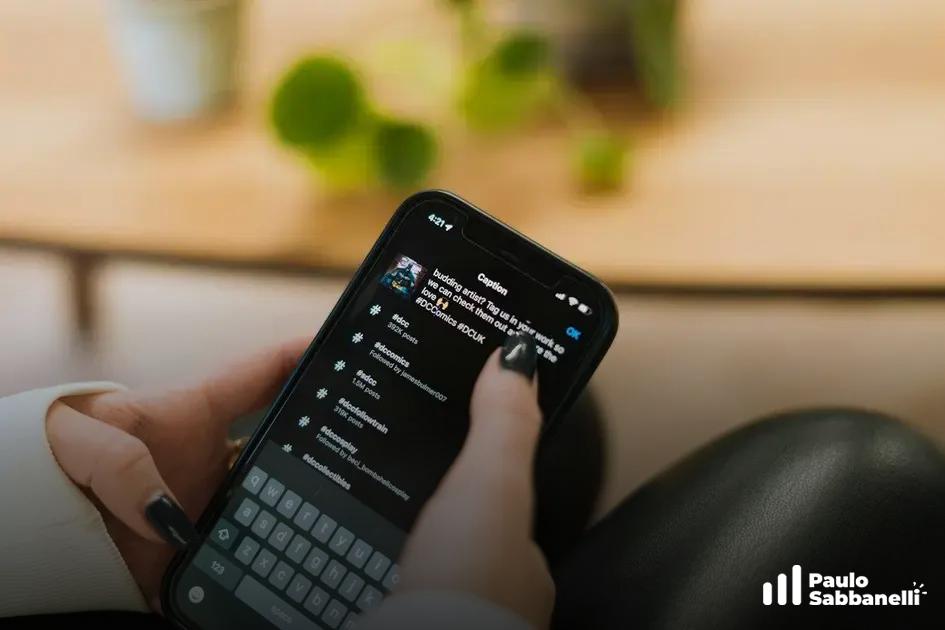 Mão com esmalte escuro segurando um celular com lista de notificações de curtidas, planta ao fundo