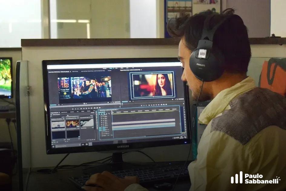 Homem com fone de ouvido edita vídeo em monitor com linha do tempo de software de edição