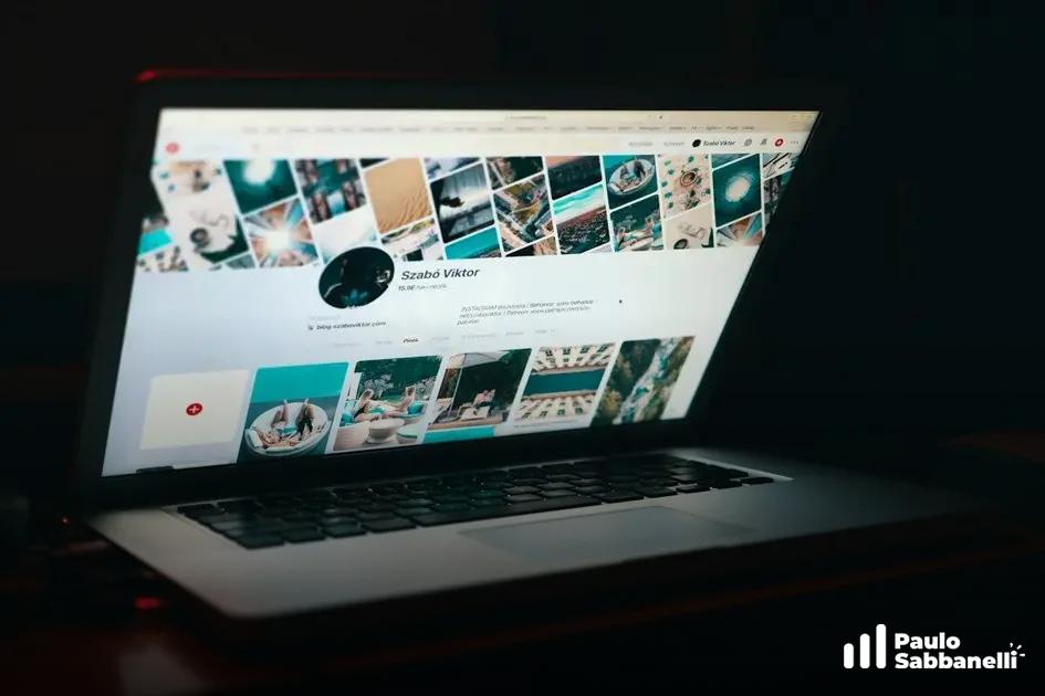 Notebook em ambiente escuro exibindo um perfil com grade de fotos em tons de turquesa