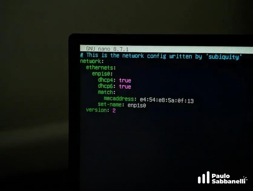 Notebook em ambiente escuro com terminal nano exibindo um arquivo de configuração de rede