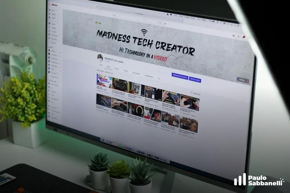 Monitor exibe canal do YouTube Madness Tech Creator com grade de vídeos em miniatura
