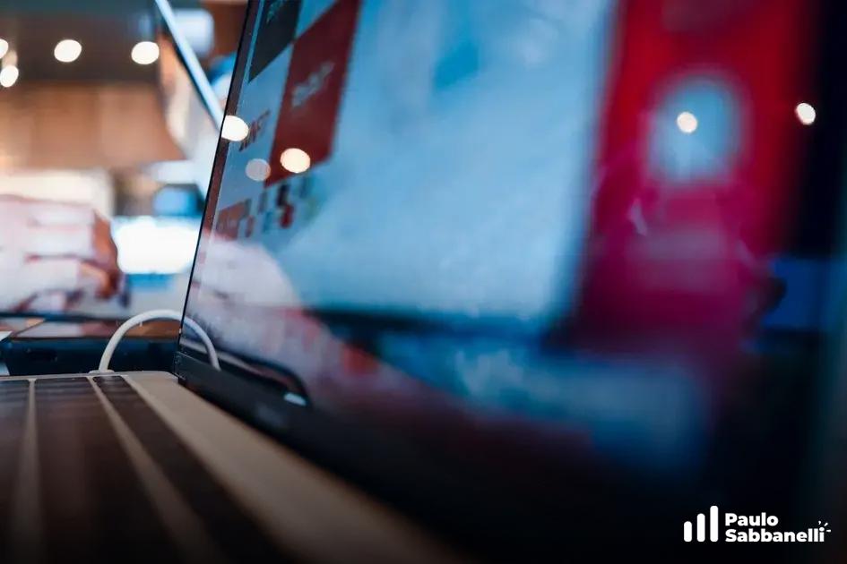 Notebook desfocado com luzes vermelhas e reflexos coloridos em ambiente escuro