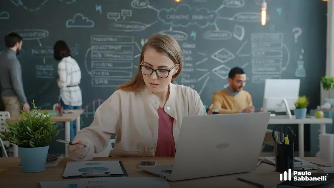 Mulher de óculos trabalha em notebook diante de parede com esquemas de marketing rabiscados