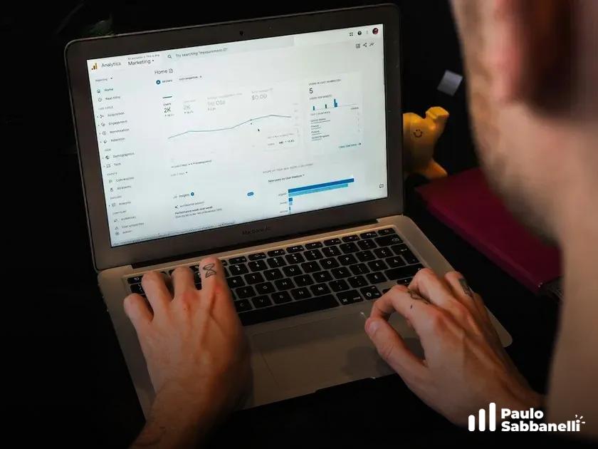 Pessoa digitando em um MacBook com painel de análise na tela e um patinho de borracha ao fundo