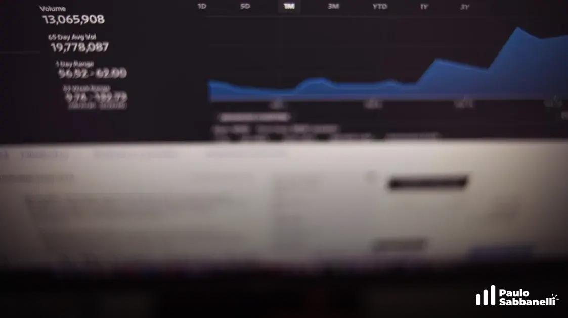 Tela desfocada de monitor mostra gráfico de ações com dados de volume e variação ao longo do ano