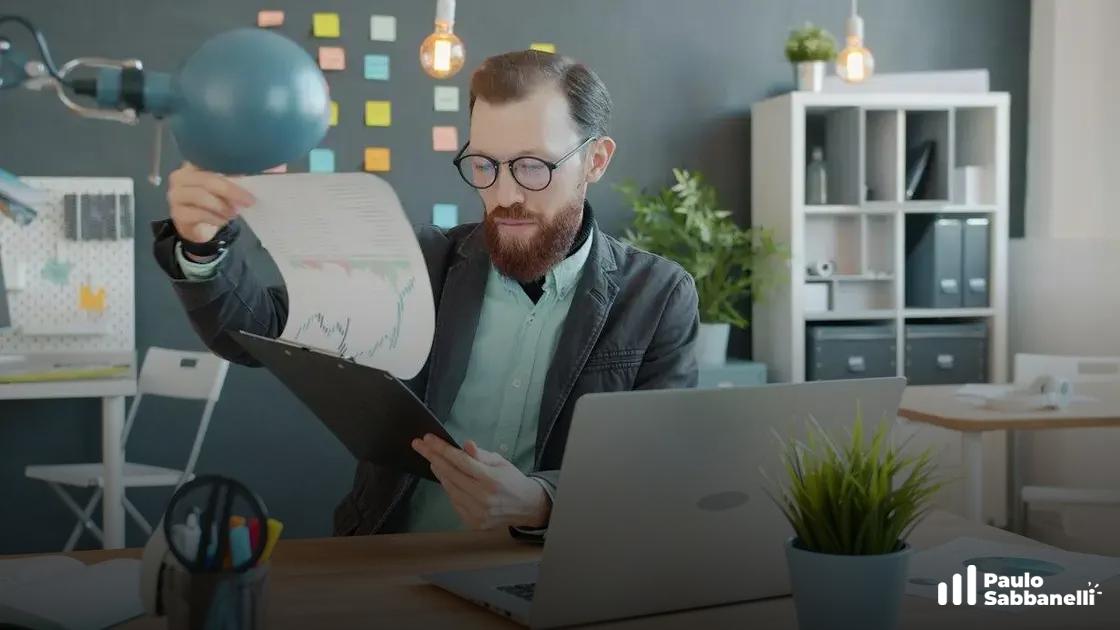 Homem de óculos segurando papéis com gráficos sob uma luminária de mesa em escritório